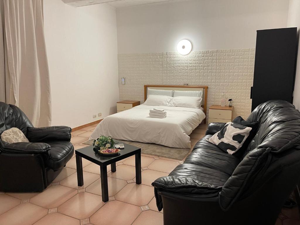 1 Schlafzimmer mit einem Bett, 2 Stühlen und einem Tisch in der Unterkunft Just Relax in Le Casette