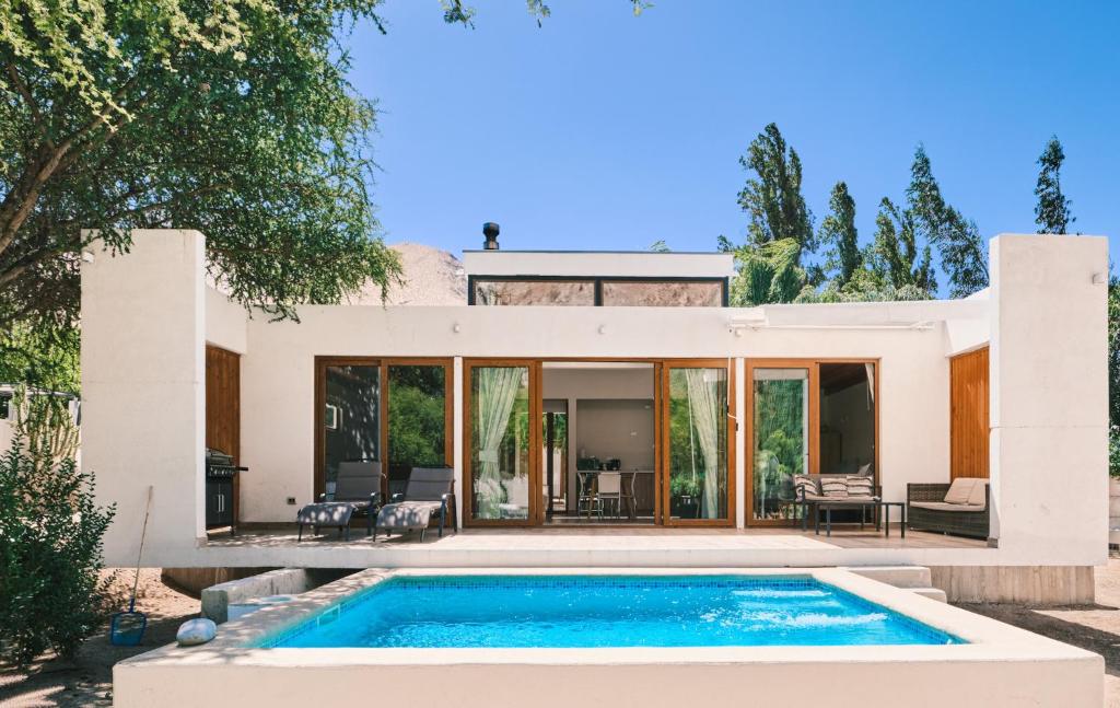 a villa with a swimming pool in front of a house at Aldea del Valle - Elqui Villas, Pisco Elqui in Pisco Elqui