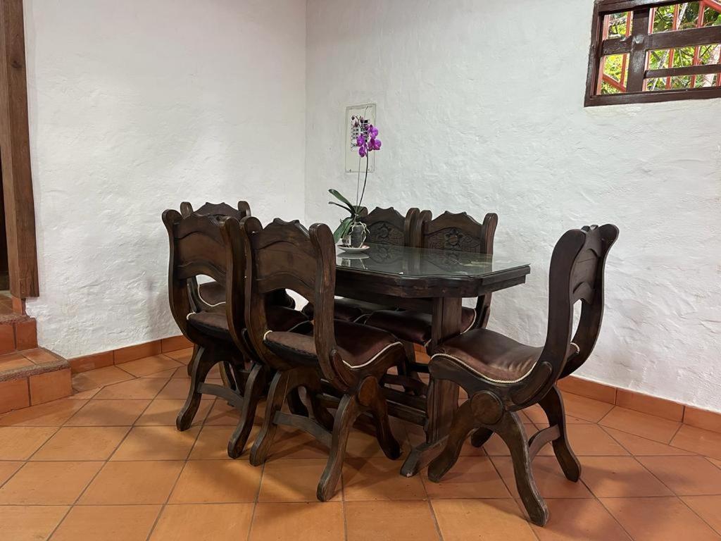 a wooden dining room table and chairs with a vase on it at Waka Maru in San Agustín