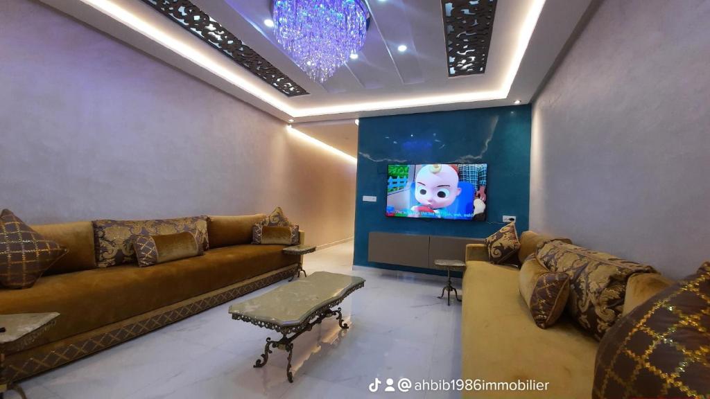 een woonkamer met een bank en een tv bij اقامة الانوار in Nador