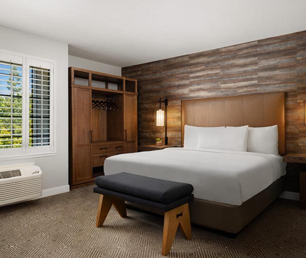 um quarto com uma grande cama branca e um banco em Napa Winery Inn em Napa