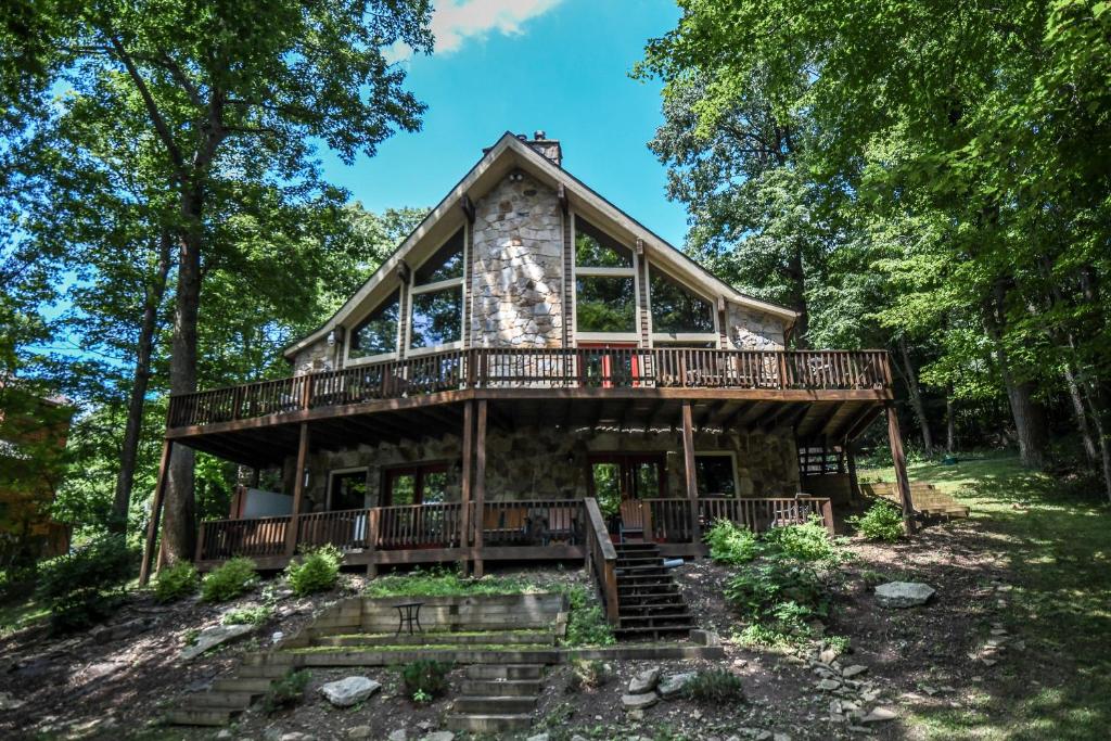 a log cabin in the woods with a wrap around deck at Slip Away Chalet in McHenry
