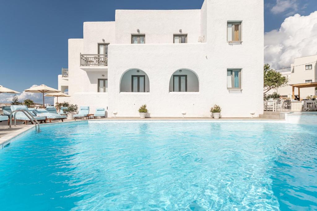 une villa avec une piscine en face d'un bâtiment dans l'établissement Anatoli Hotel, à Naxos Chora