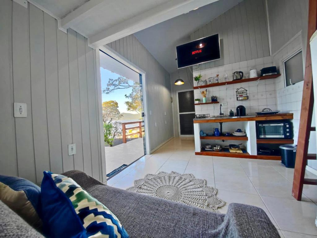 a living room with a couch and a tv at TINY HOUSE - Privacidade e Vista Exclusiva da Ilha in Palhoça