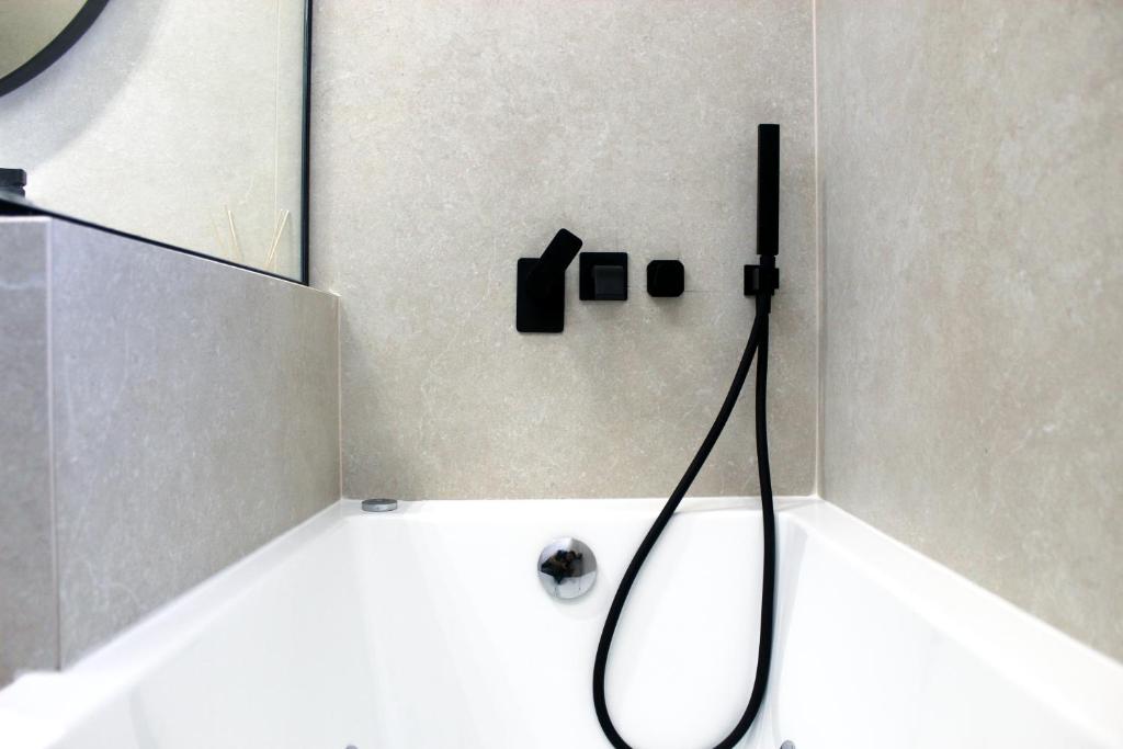 a bathroom with a bath tub with a shower head at Villa Almy in Plaka