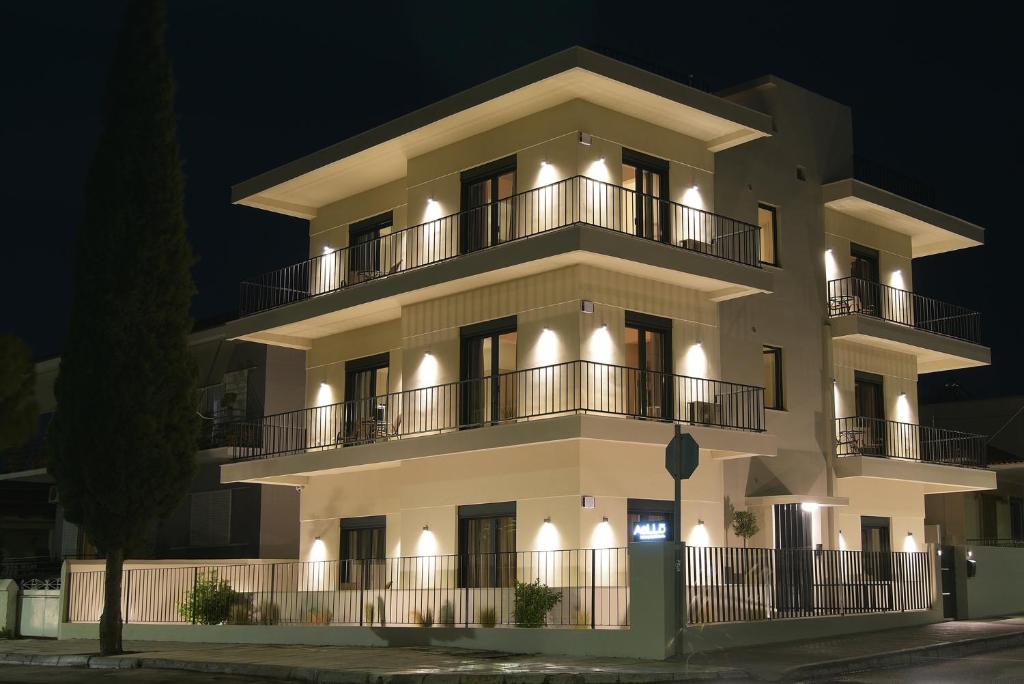 a large white building with balconies at night at Aellō luxury apartments in Markopoulo