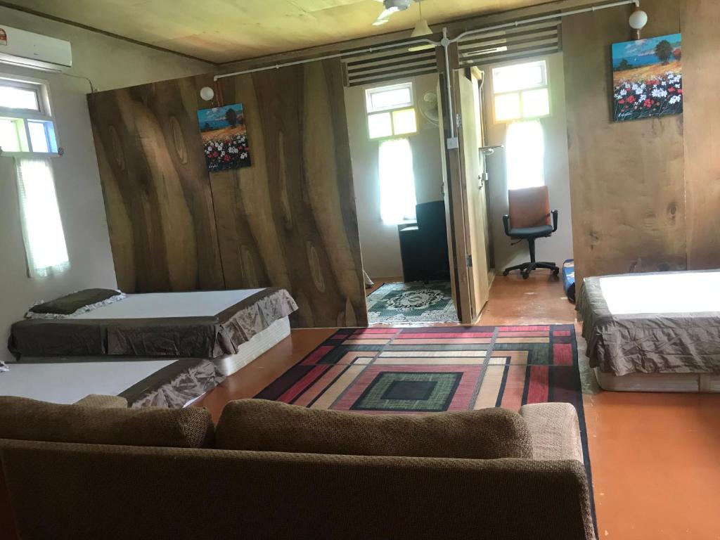 a living room with two beds and a couch at Anjung Afilia 1 in Kuala Kangsar