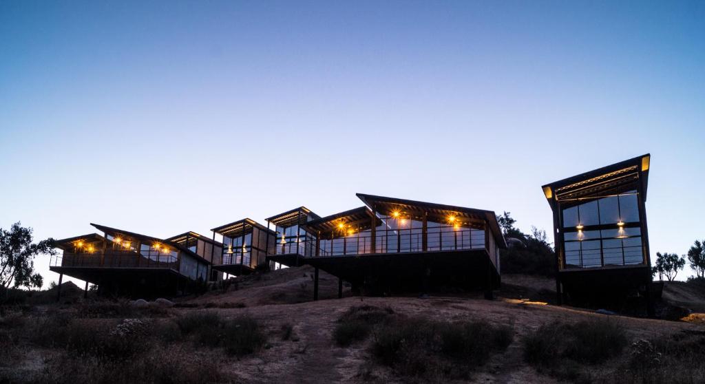 a row of houses on top of a hill at night at Origen75 Loft - Villas - Skypool - Viñedo, Valle de Guadalupe in Valle de Guadalupe