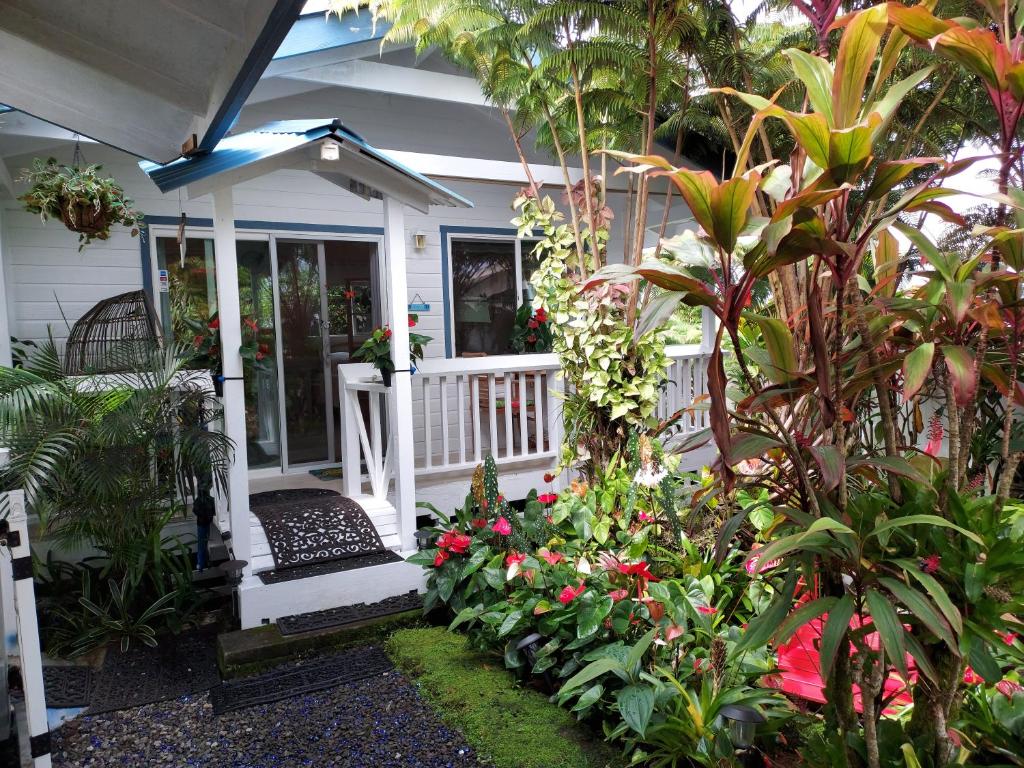 a porch of a house with flowers and plants at Paradise Cottage at Anthurium Hale in Hilo