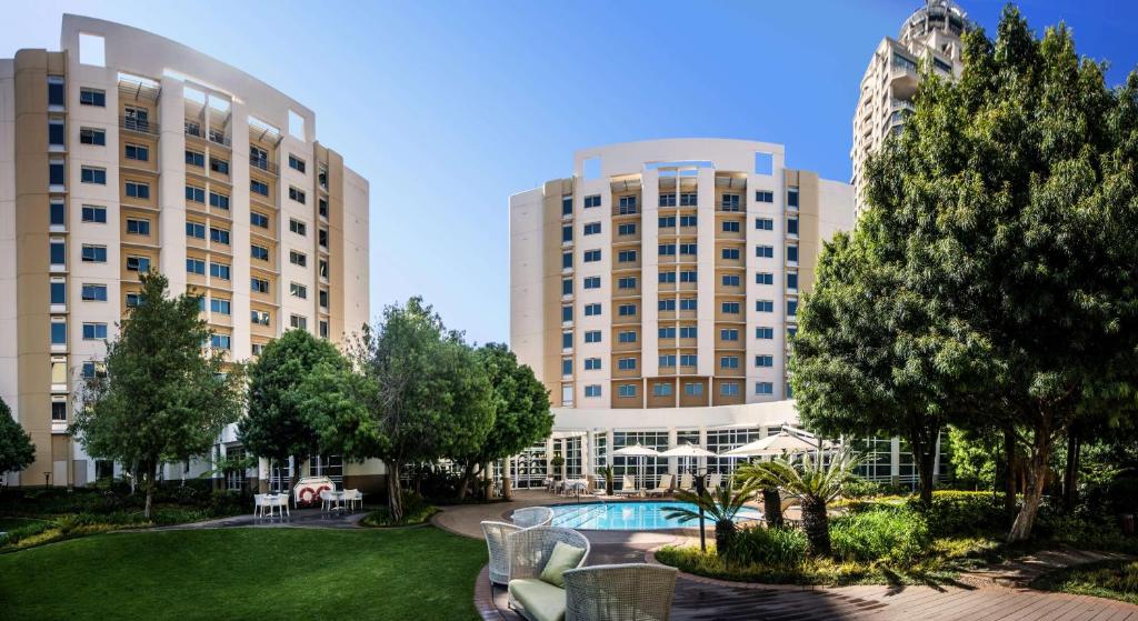 a view of two large buildings with a park at Garden Court Sandton City in Johannesburg