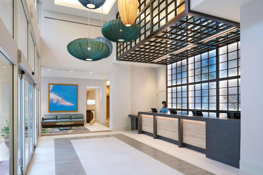 a lobby of a hotel with a woman sitting at a desk at Waikiki Malia in Honolulu