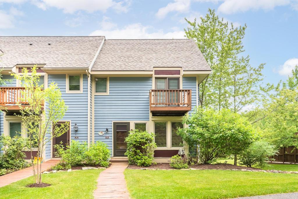 a blue house with a porch and a balcony at Beary Relaxing in McHenry