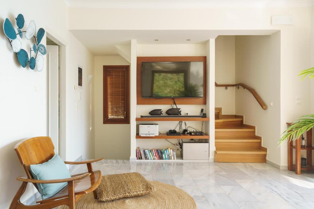 a living room with a chair and a staircase at Villa Almy in Plaka