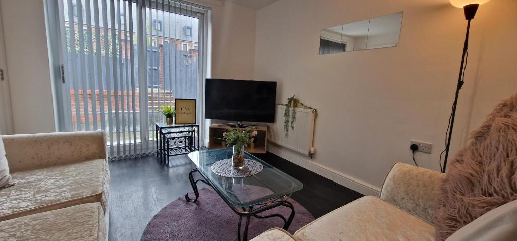 a living room with a couch and a table and a tv at Relax Inn in Liverpool