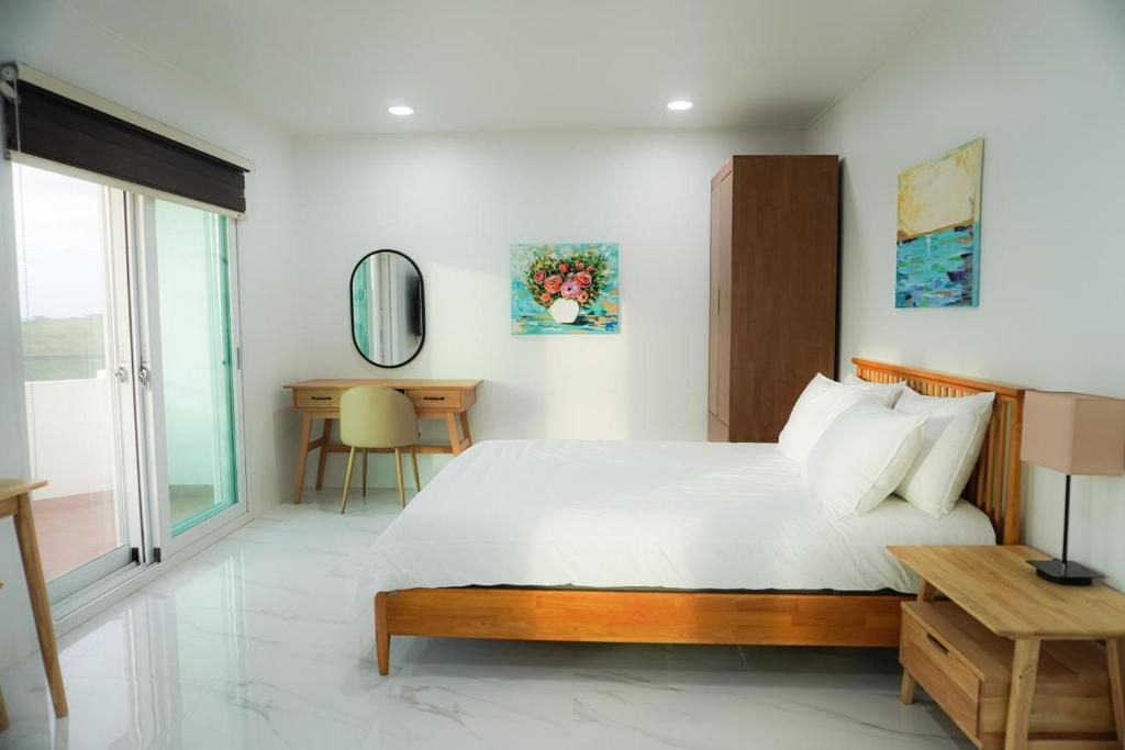 a bedroom with a large bed and a desk at Mariana Suites in San Roque