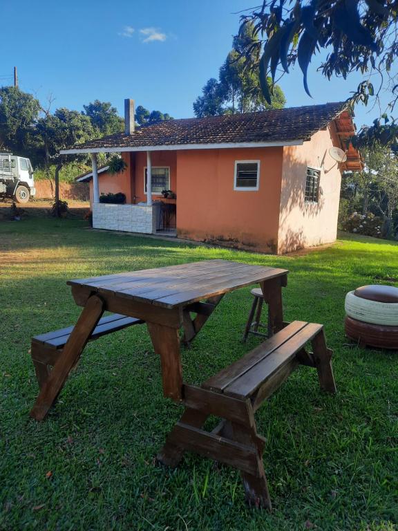 einem Picknicktisch und einer Bank vor einem Haus in der Unterkunft Morada Jaguary in Camanducaia