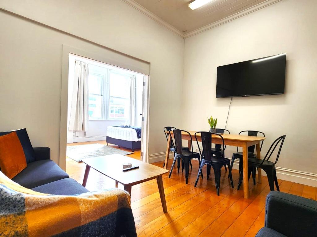 a living room with a table and a tv at U Suites on Cuba in Wellington