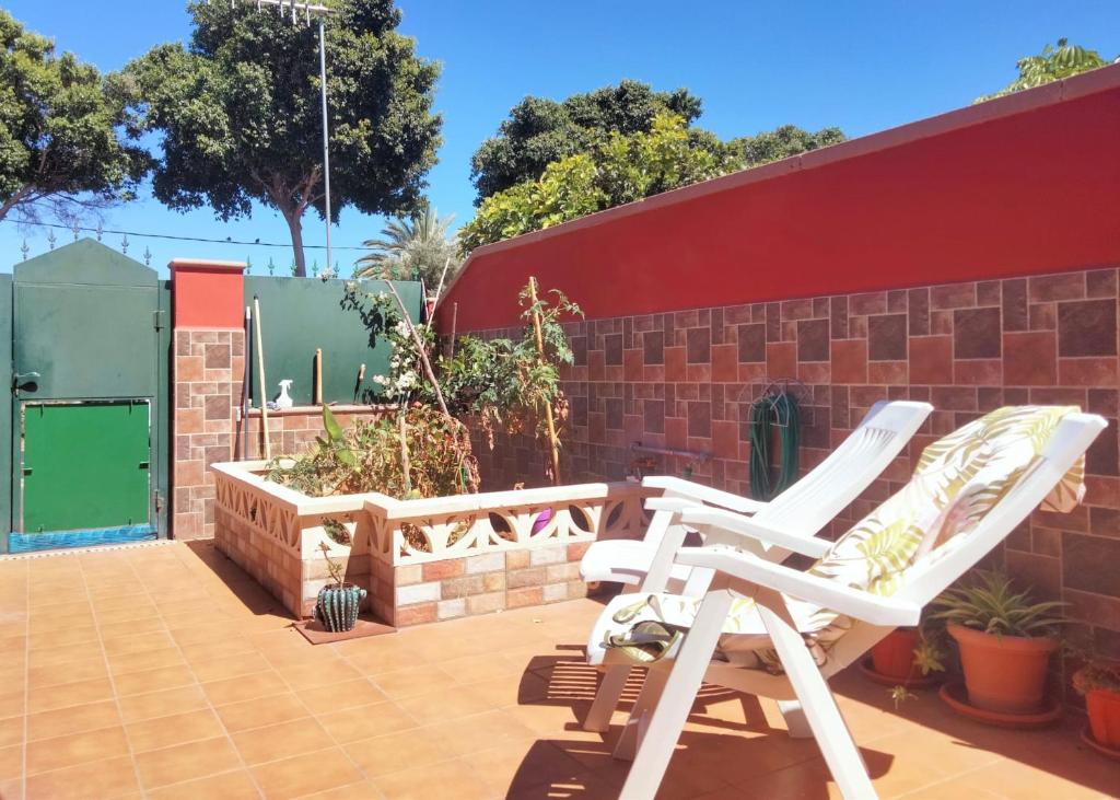 a pair of white chairs sitting on a patio at La casita in Arona