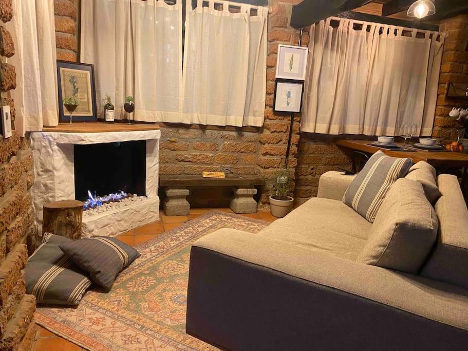 a living room with a couch and a fireplace at Tiny Chalet in the clouds in Medellín
