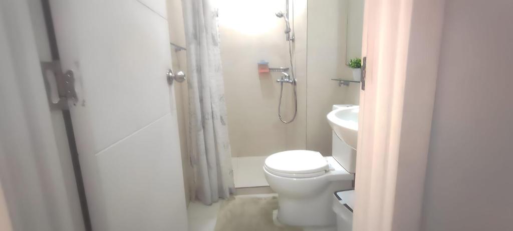 a bathroom with a toilet and a shower and a sink at Aveline Suites Cozy Skyline View ACQUA Private Residences near Rockwell Makati in Manila