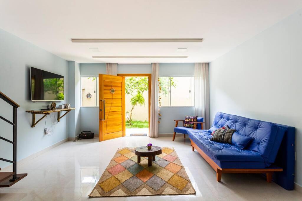 a living room with a blue couch and a table at Casa Maha in Niterói