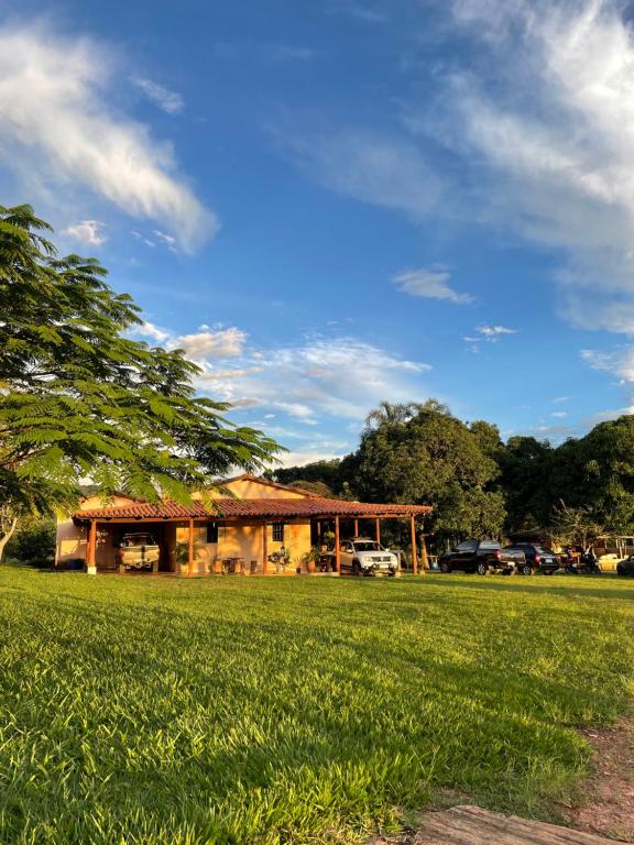 a house in the middle of a grass field at Chácara recanto Feliz in Pirenópolis