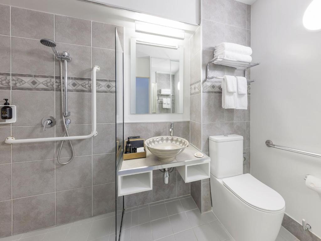 a bathroom with a toilet and a sink and a shower at JetPark Auckland Airport Hotel in Auckland