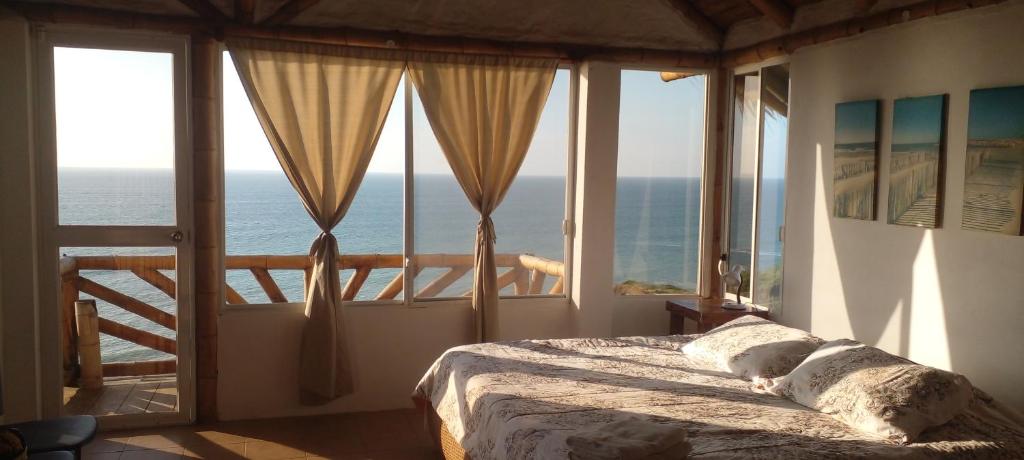 a bedroom with a bed with a view of the ocean at Casa Las Mantas in Santa Marianita