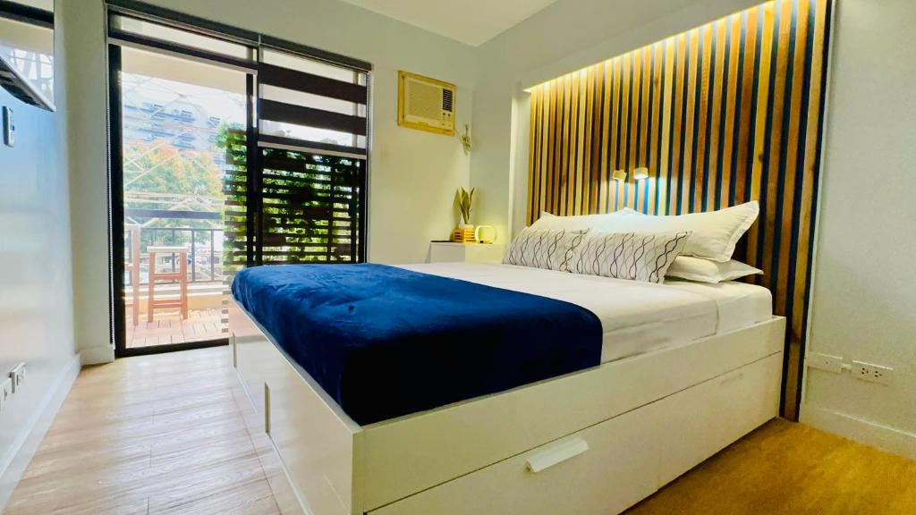 a bedroom with a large bed and a large window at Beyond Zurich HOME Staycation in Manila