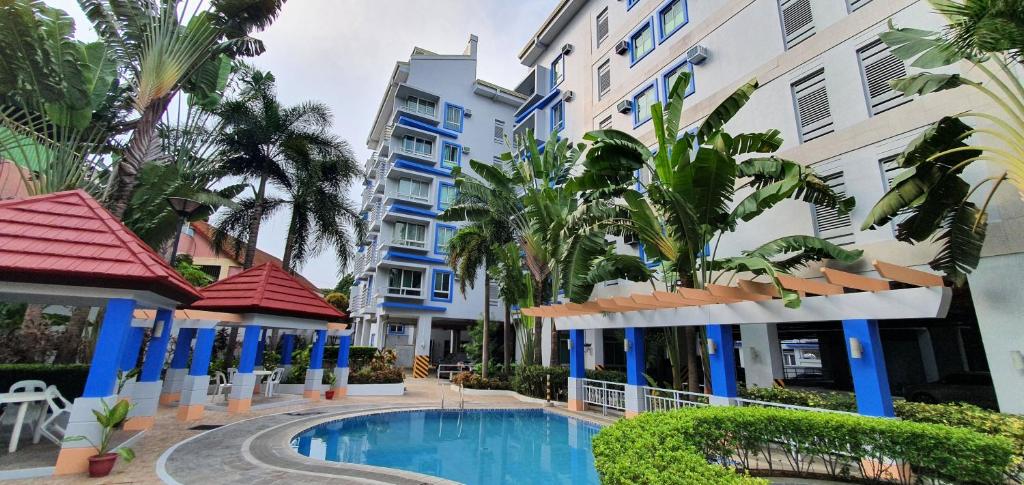 - une piscine en face de certains bâtiments dans l'établissement SCANDIA SUITES AT SOUTH FORBES Homey & Cozy 2-Bedroom Condo, à Silang