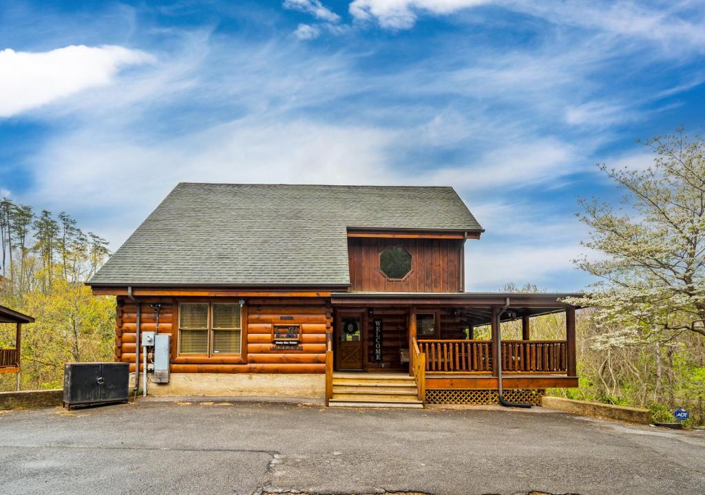 a log cabin with a porch and a driveway at 2-Bedroom Cabin with 2 Master Suites, Loft, Half-Bath and hot tub in a Serene Resort Setting in Sevierville