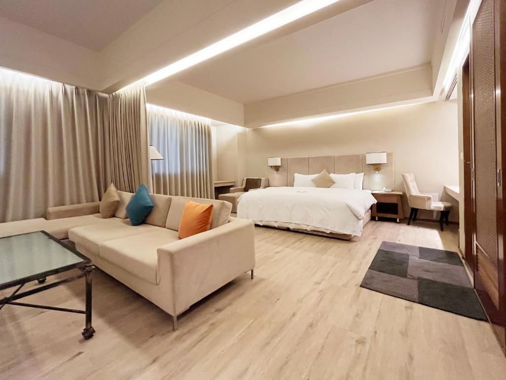 a hotel room with a bed and a couch at Jia Hsin Garden Hotel in Tainan