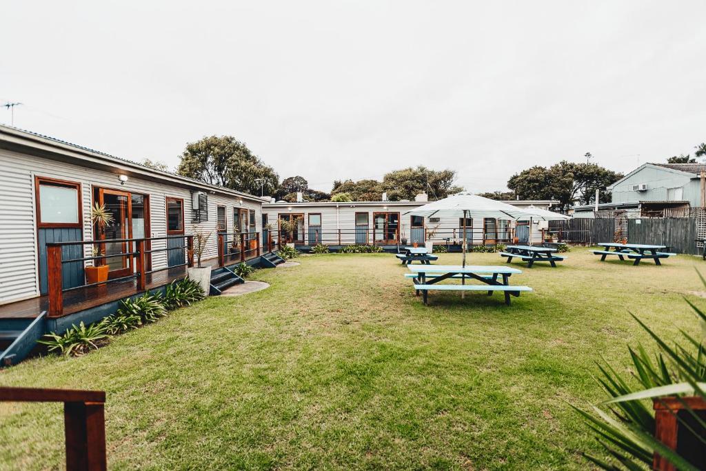a large yard with picnic tables in front of buildings at Beach Holiday Apartments in Rye