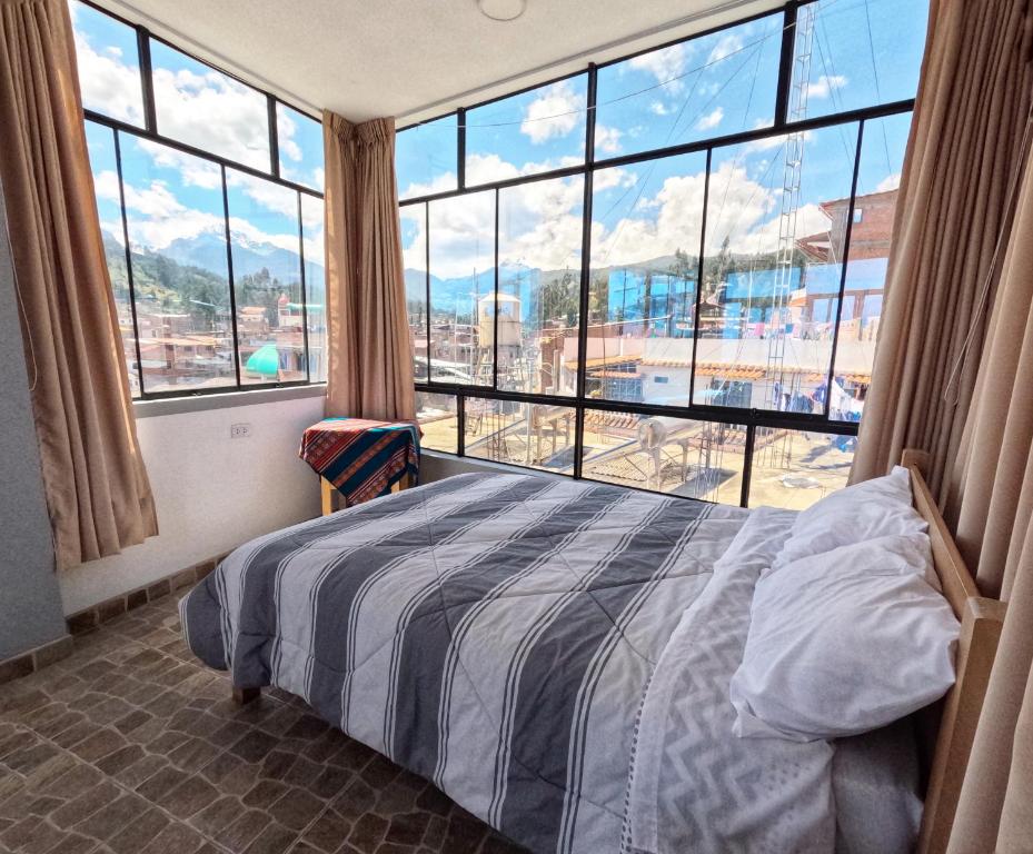 a bedroom with a bed and a large window at Makalu Lodge in Huaraz