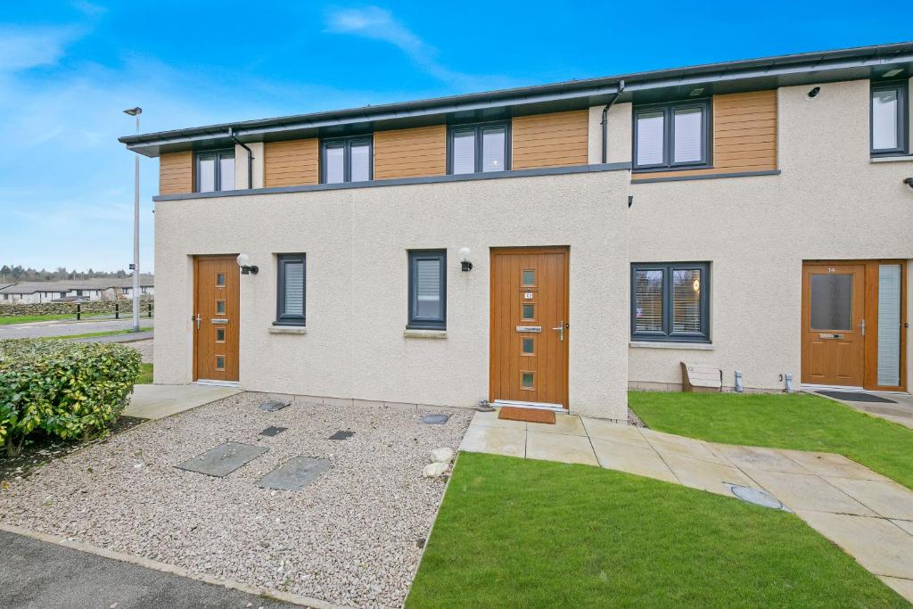 a large house with brown doors and a yard at Maidencraig Court House ✪ Grampian Lettings Ltd in Aberdeen