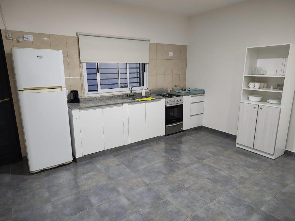 an empty kitchen with white cabinets and appliances at Duplex Del Valle in San Fernando del Valle de Catamarca