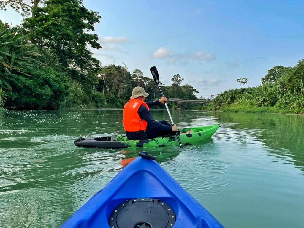 un hombre sentado en un kayak en un río en Finca D'Elía Lodge, en Puerto Limón