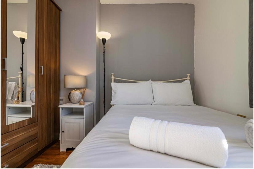 ein Schlafzimmer mit einem großen weißen Bett mit weißen Kissen in der Unterkunft 3Bed house near Nottingham city centre in Nottingham