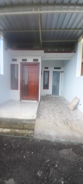 a white building with red doors and a parking lot at Alvaiz home in Gunungsan