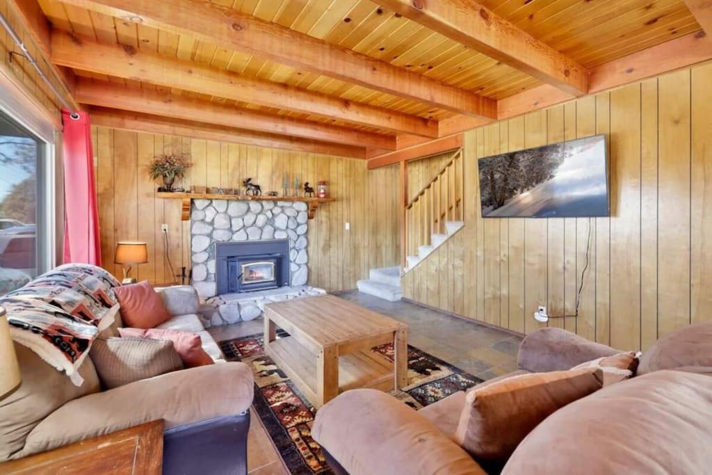 ein Wohnzimmer mit einem Sofa und einem Kamin in der Unterkunft The Getaway Cabin in Big Bear City