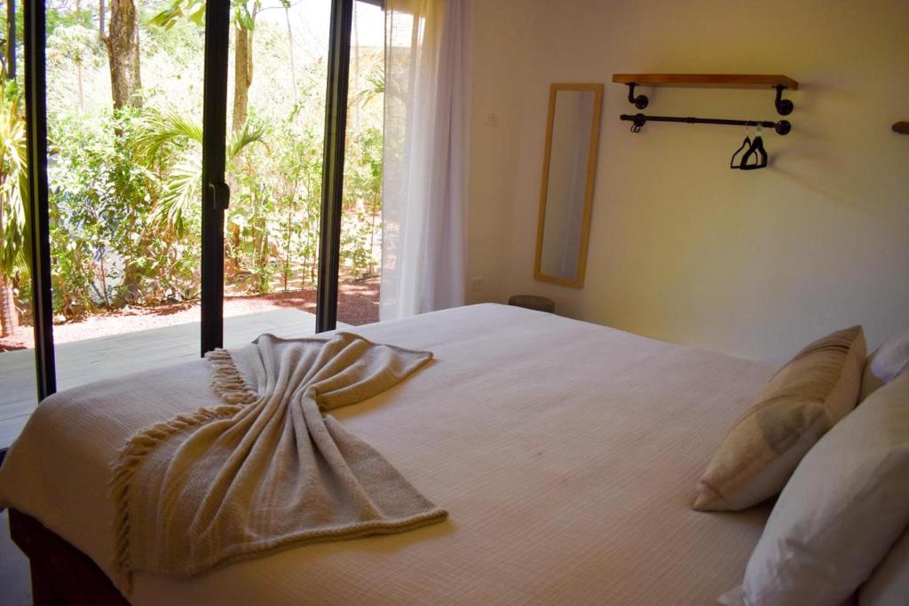 a bedroom with a large white bed with a window at Blue Window Boutique Villas Hotel in Playa Junquillal