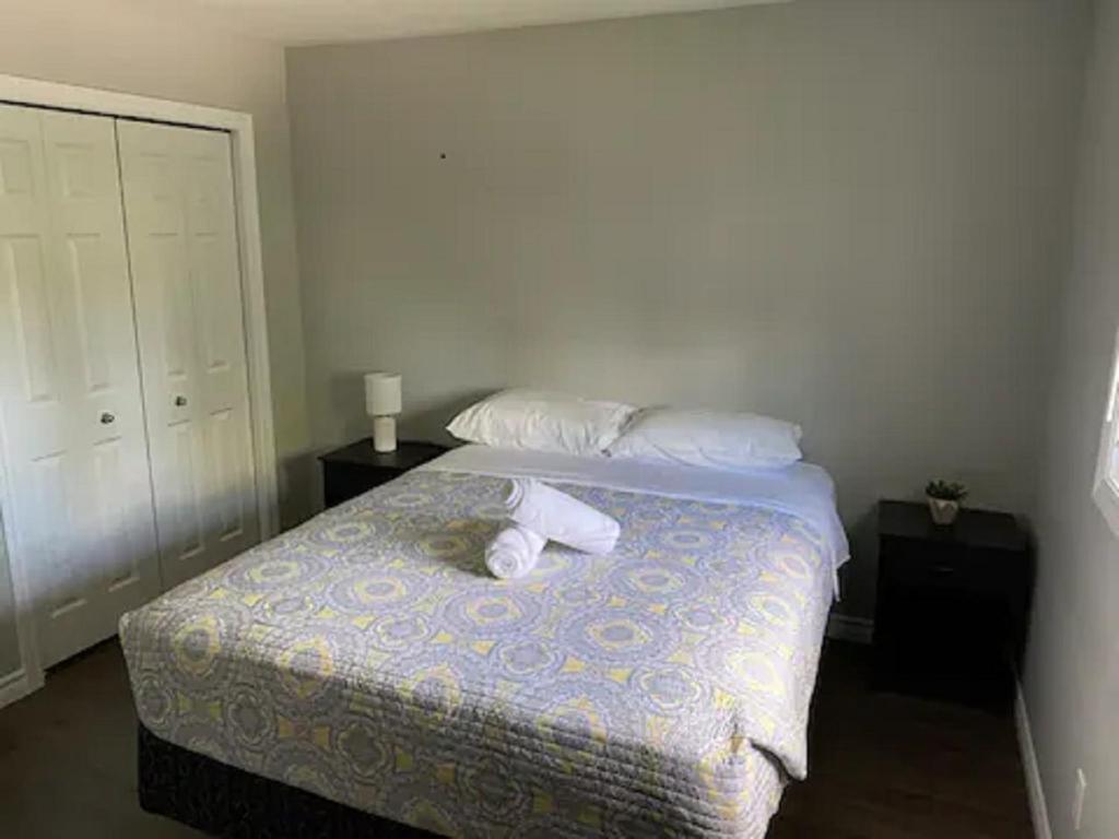a bedroom with a bed with two towels on it at Nice Rooms Stay - Unit 2 in Kingston