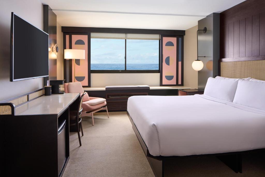 a hotel room with a bed and a desk at Hotel Renew in Honolulu