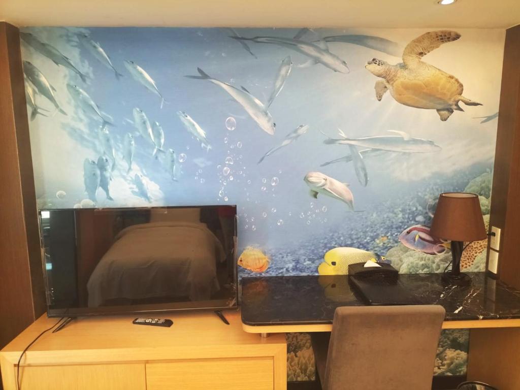 a bedroom with a fish mural on the wall at JinShan Sakura Bay Hot Spring Hotel in Jinshan