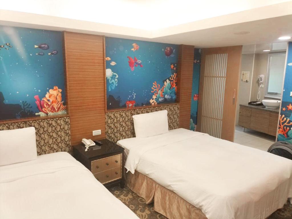 a hotel room with two beds and an aquarium at JinShan Sakura Bay Hot Spring Hotel in Jinshan
