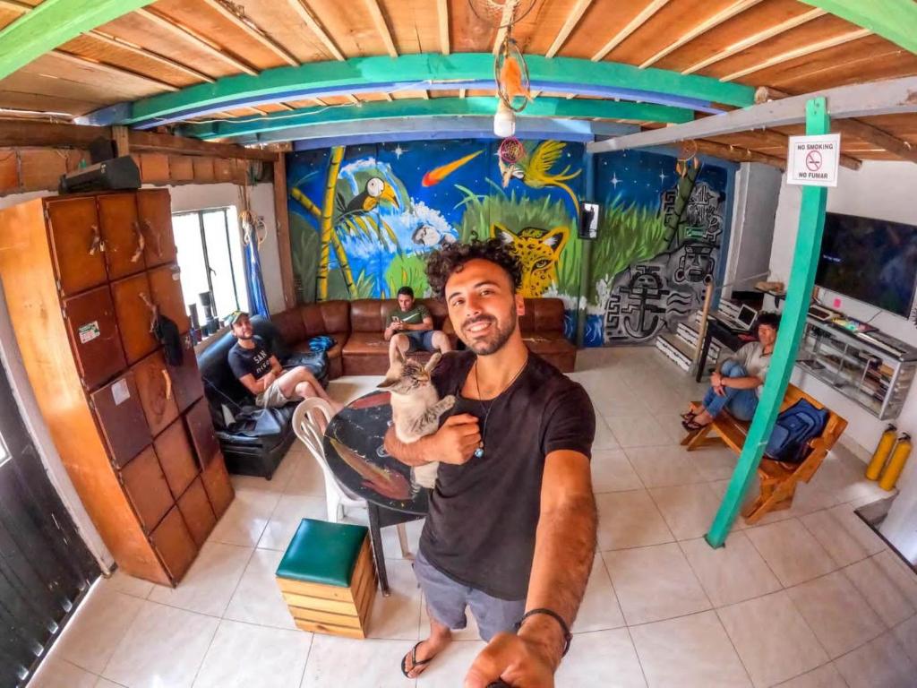 a man holding a dog in a room at Hostal Música y Arte in San Agustín