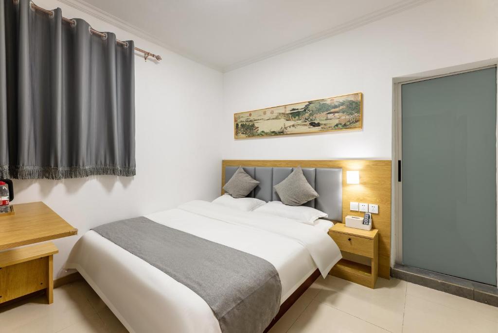 Postel nebo postele na pokoji v ubytování Happy Dragon Hotel -- Nearby Tiananmen square & Forbidden City & Wangfujing Street & Line 5,6,8 Subway Nearby & Free coffee & Free laundry & Fluent English speaking & Tourist attractions ticket service & Free WiFi unlimited for Western software