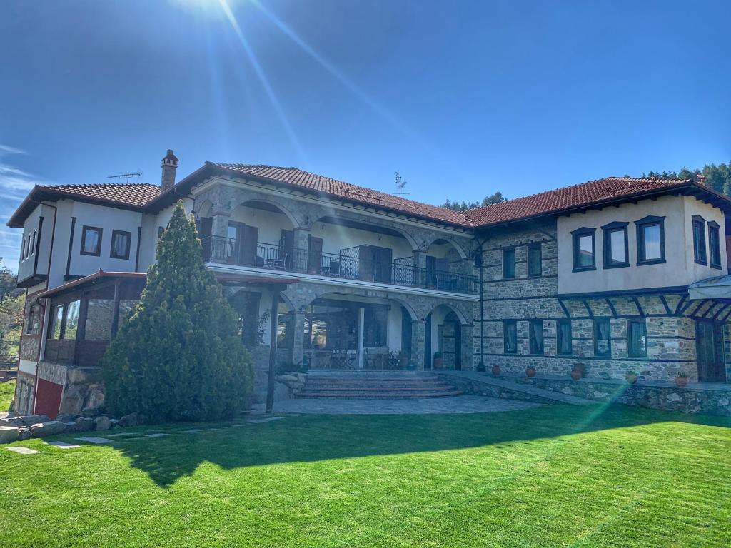 a large house with a green lawn in front of it at Hotel Apsis in Emporio