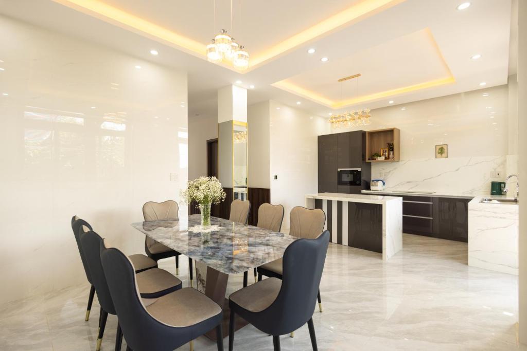 a kitchen and dining room with a table and chairs at Happy Home Da Lat in Da Thanh