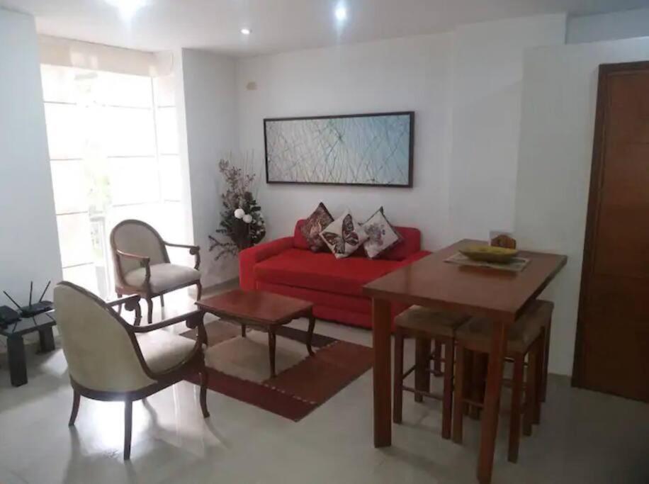 uma sala de estar com um sofá vermelho e uma mesa em Apartamento Cali-Granada Piscina em Cali